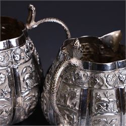 Three piece Indian silver tea service, comprising teapot, twin handled open sucrier and cream jug, each with embossed animal decoration with fish border, serpent handles and elephant finial, teapot H17cm