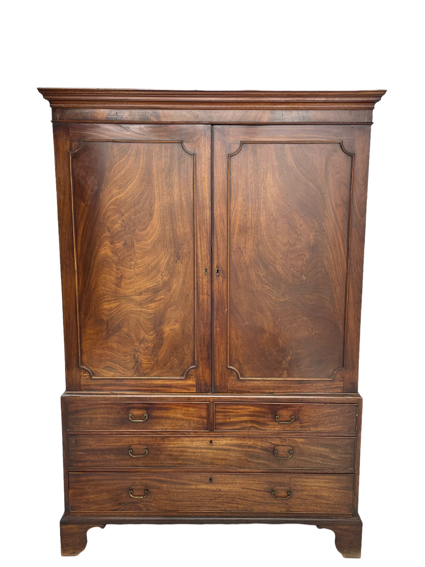 George III mahogany linen press, projecting cornice over two figured doors enclosing five linen slides, the lower section fitted with two short and two long drawers, on bracket feet