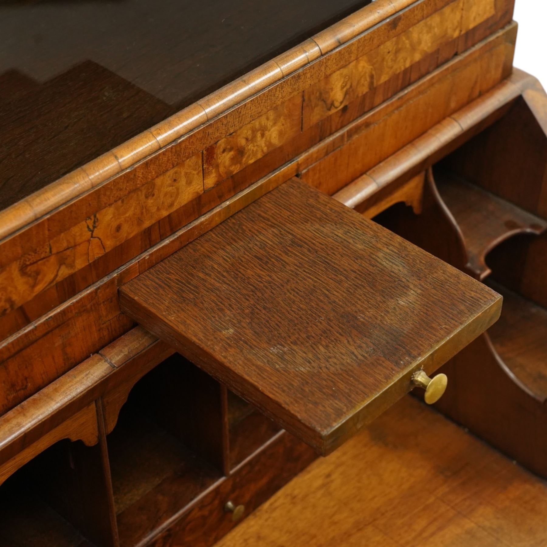 Quality George I figured and burr walnut bureau-cabinet of unusually small proportions, the projecting cavetto cornice over a glazed and banded door enclosing four adjustable shelves, with a candle slide below, the book-matched and banded veneer fall-front enclosing a fitted interior with pigeonholes, correspondence drawers and original trinket boxes and inkwells, over two pull-out stays and four graduating long drawers with banded facias and pressed brass escutcheons and pull handles, lower moulded edge on bracket feet
Provenance: purchased Sotherby's 1977