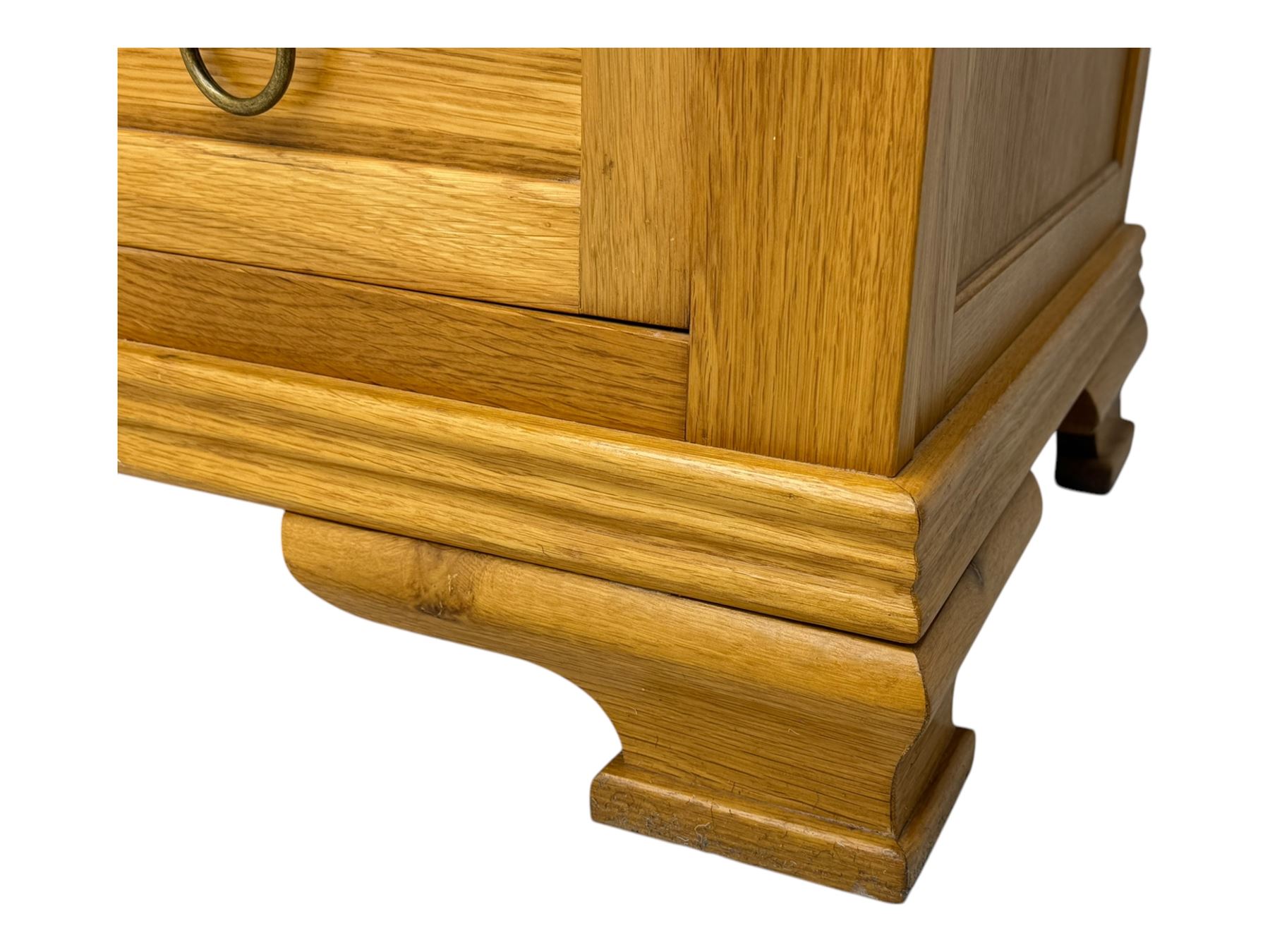 Frank Hudson - contemporary light oak chest, rectangular moulded top over two short and three long drawers, brass oval backplates with circular drop handles, on a moulded plinth base with bracket feet