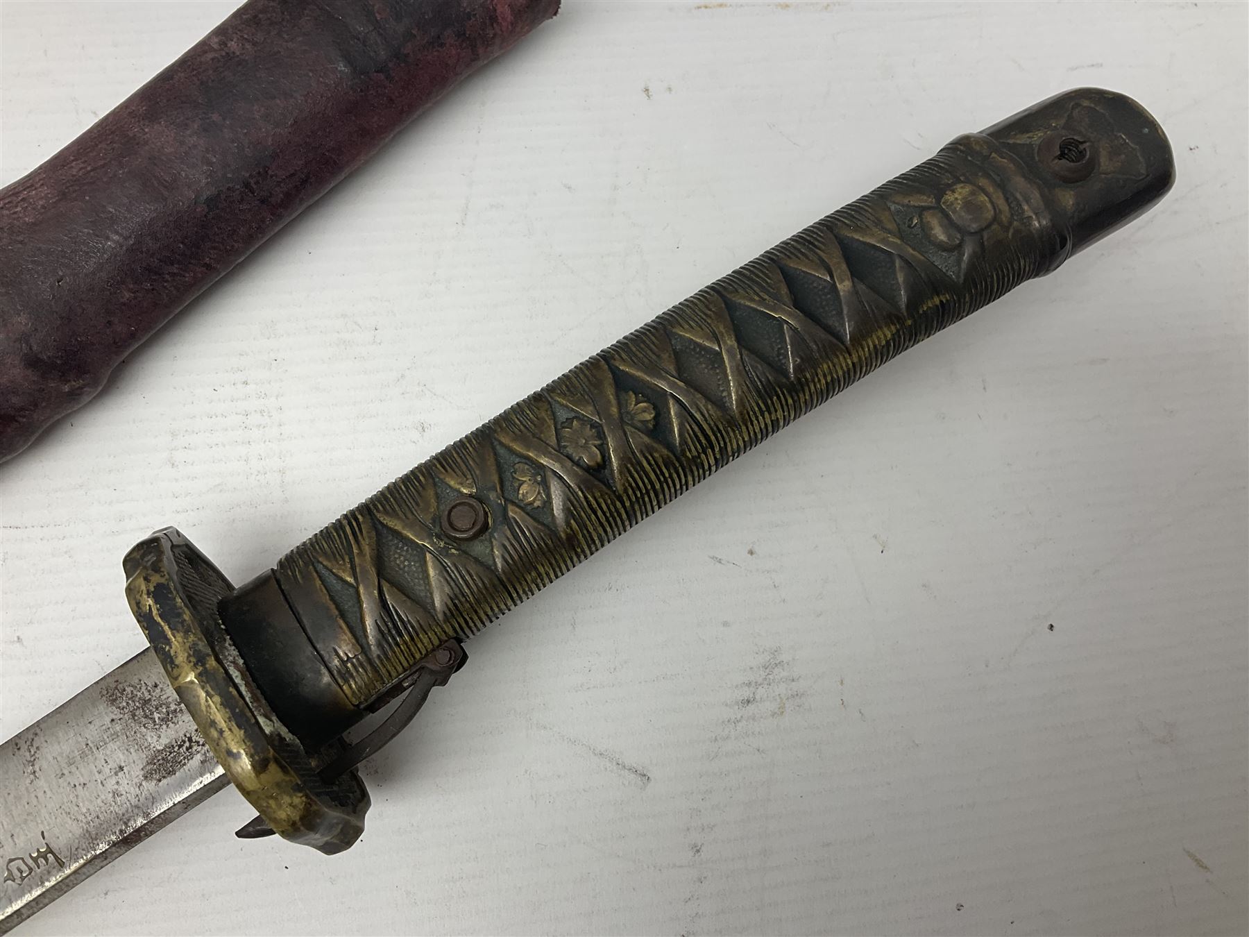 Copy of a WWII Japanese NCO sword, the 65cm slightly curving blade stamped with pseudo Japanese characters and cast brass simulated cord bound grip; in officer's leather bound field scabbard L97cm overall