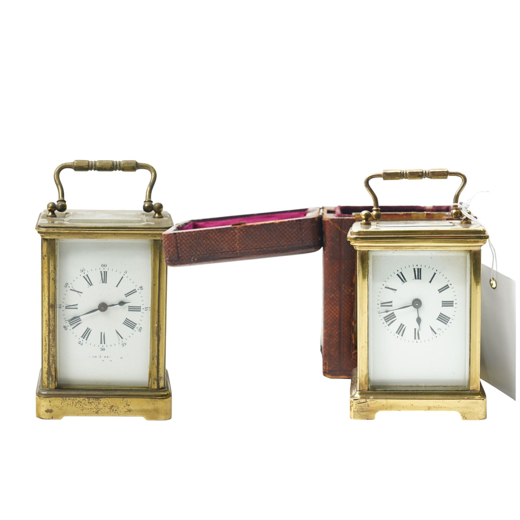 Two early 20th century 8-day French Carriage clocks- one with its original traveling case, lever platform escapement, enamel dial and Roman numerals, the other with a cylinder platform escapement, enamel dial with Roman numerals and five minute Arabic's.  