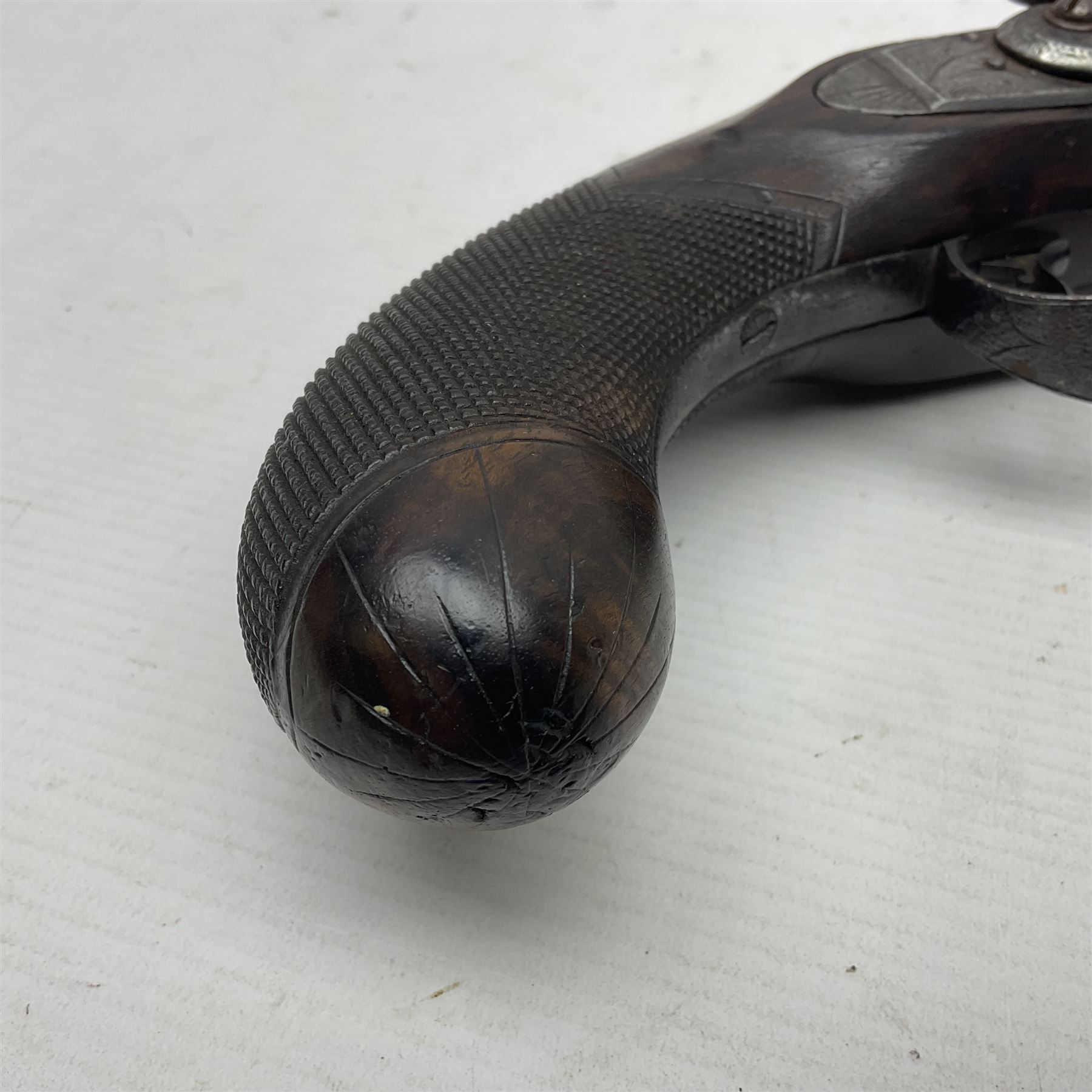 Early 19th century 16-bore flintlock single barrel travelling pistol, the 21.5cm stub twist octagonal barrel with two barrel pins and ramrod under, engraved lock plate with roller frizzen, engraved trigger guard with pineapple finial, walnut stoock with chequered grip L40cm overall