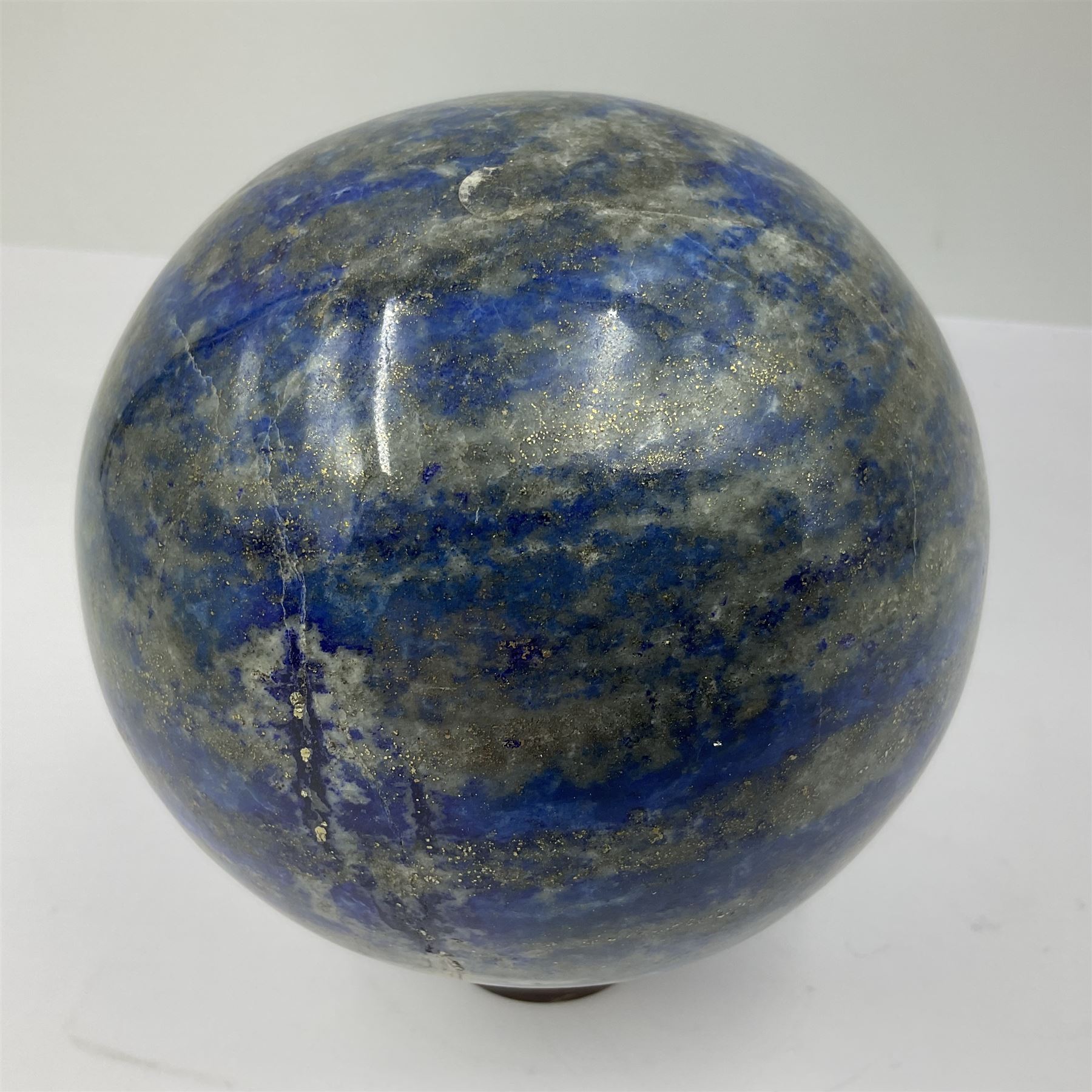 Lapis lazuli sphere upon a carved wooden base 