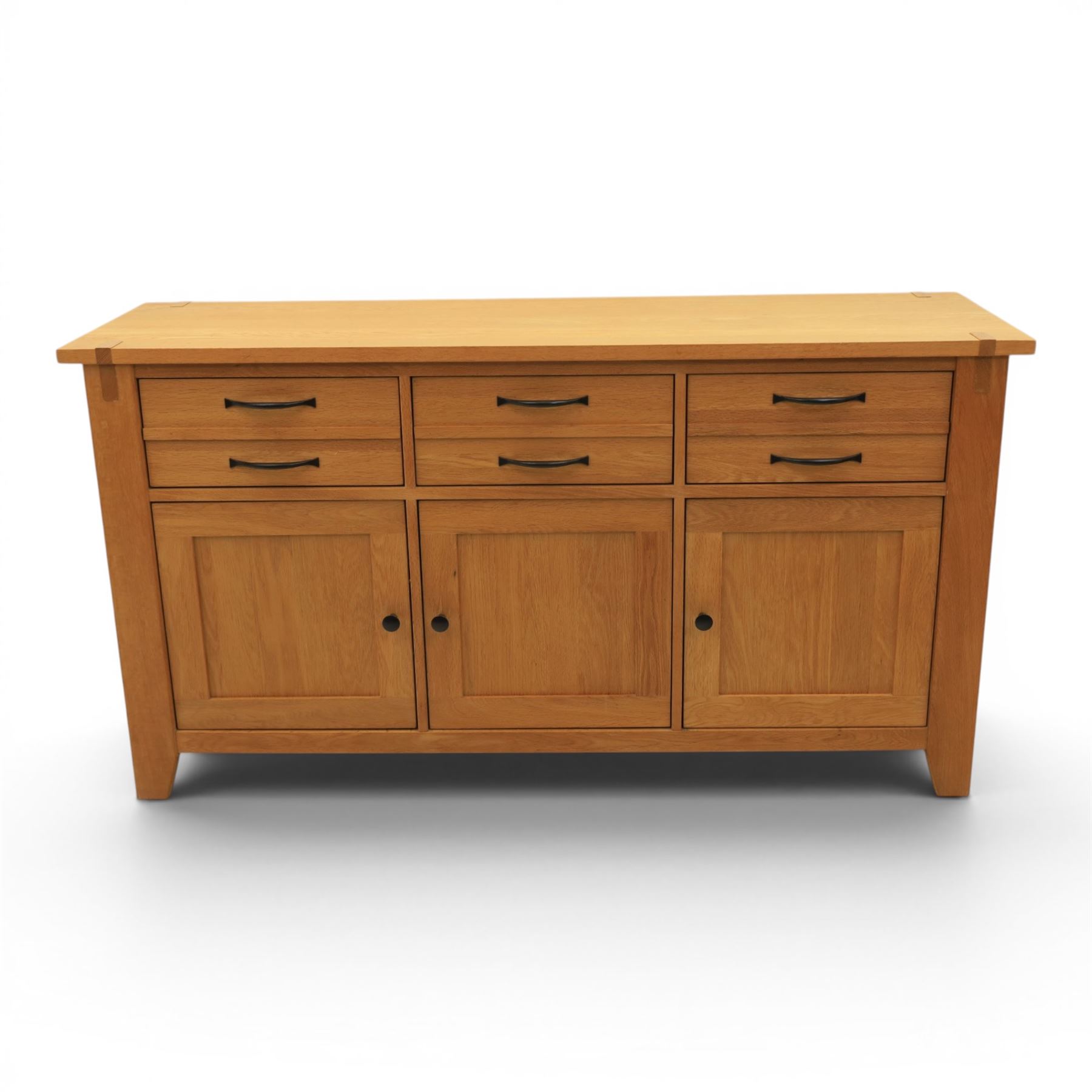 Contemporary Oak sideboard, rectangular top with tenon detailing, three drawers over three cupboard doors, blackened metal handles, raised on square supports