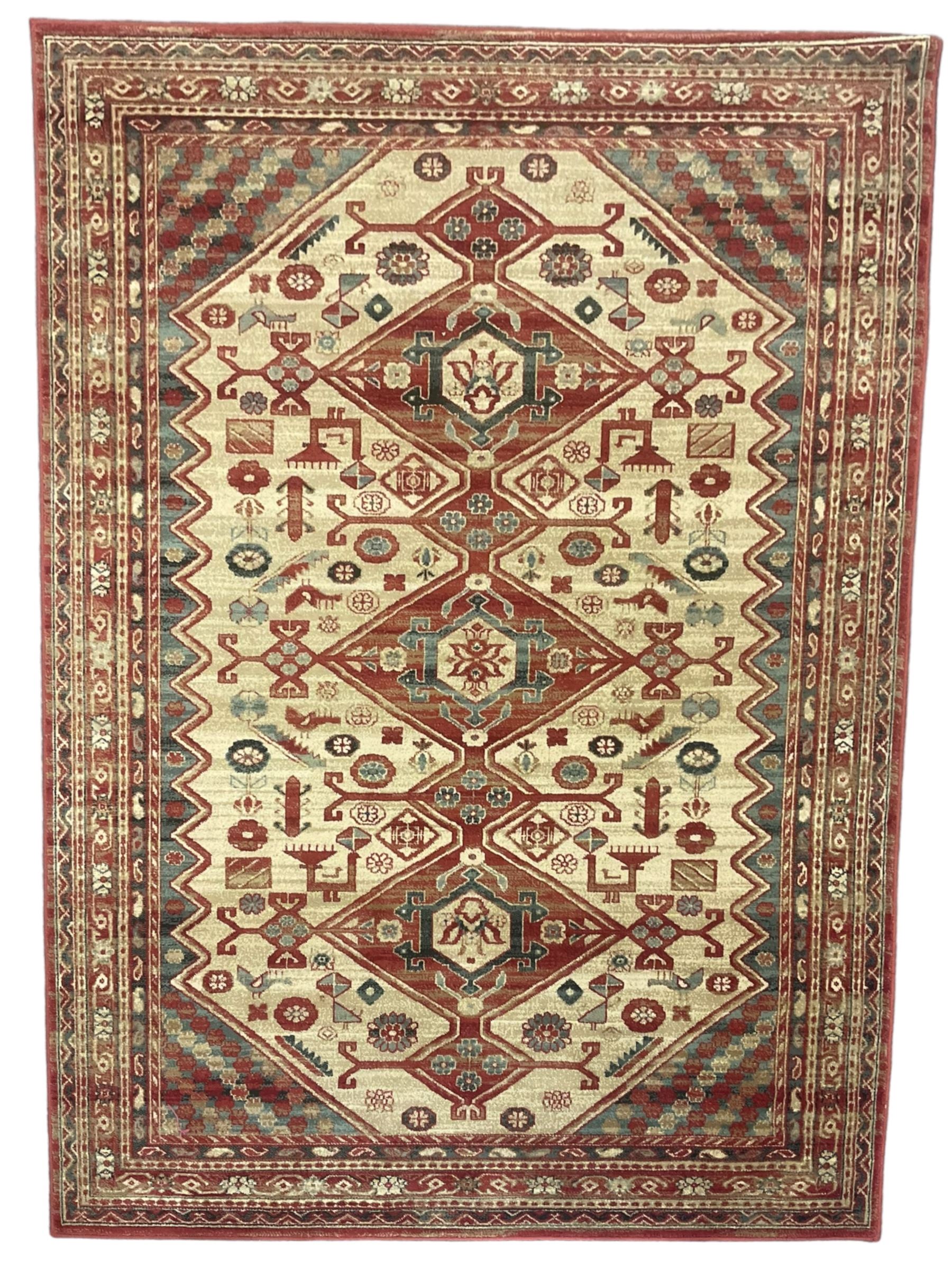 Persian design red ground rug, the field decorated with three interlinked lozenges and small stylised plant motifs, the multiple band border decorated with Boteh and floral motifs