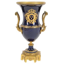 19th century Sevres style ormolu mounted porcelain twin handled urn, the body decorated with a gilt crowned crest of three fleur de lis against a cobalt ground, with spurious Sevres mark beneath, H26cm
