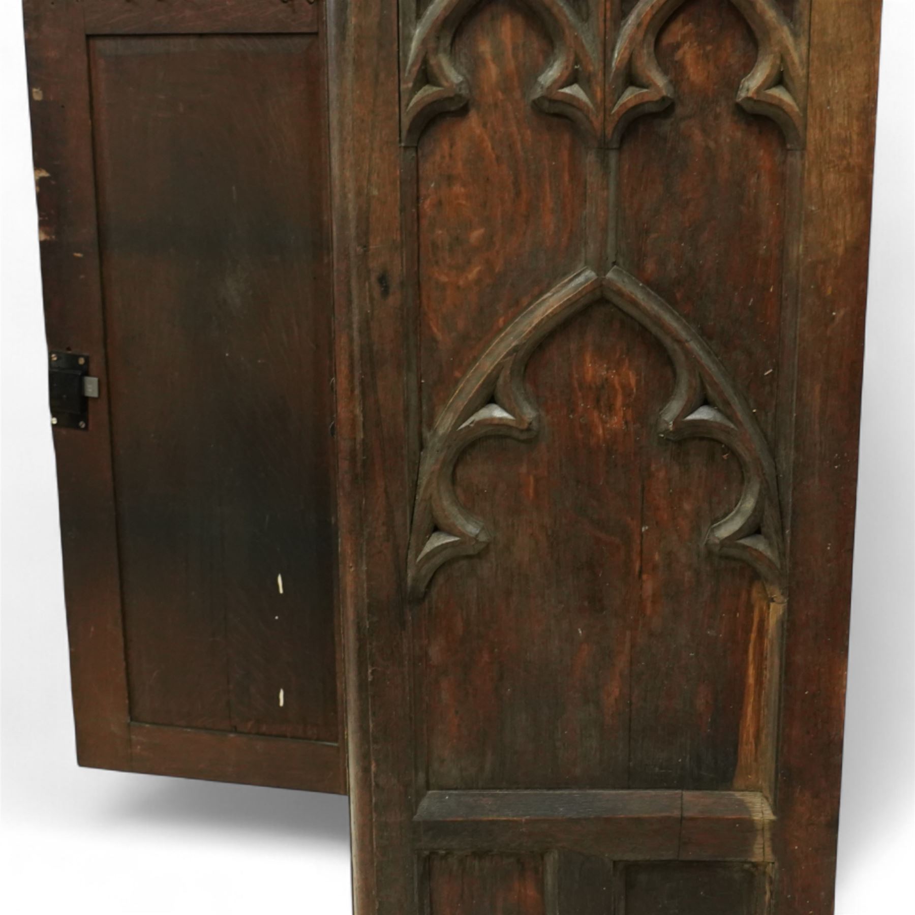 19th century Gothic Revival oak Sacristy vestment cupboard of tall proportions, fitted with two ecclesiastical trefoil moulded panelled doors enclosing four shelves, flanked by a chamfered corner, the side panelled and moulded with matching sacristic architectural mouldings, on skirted base