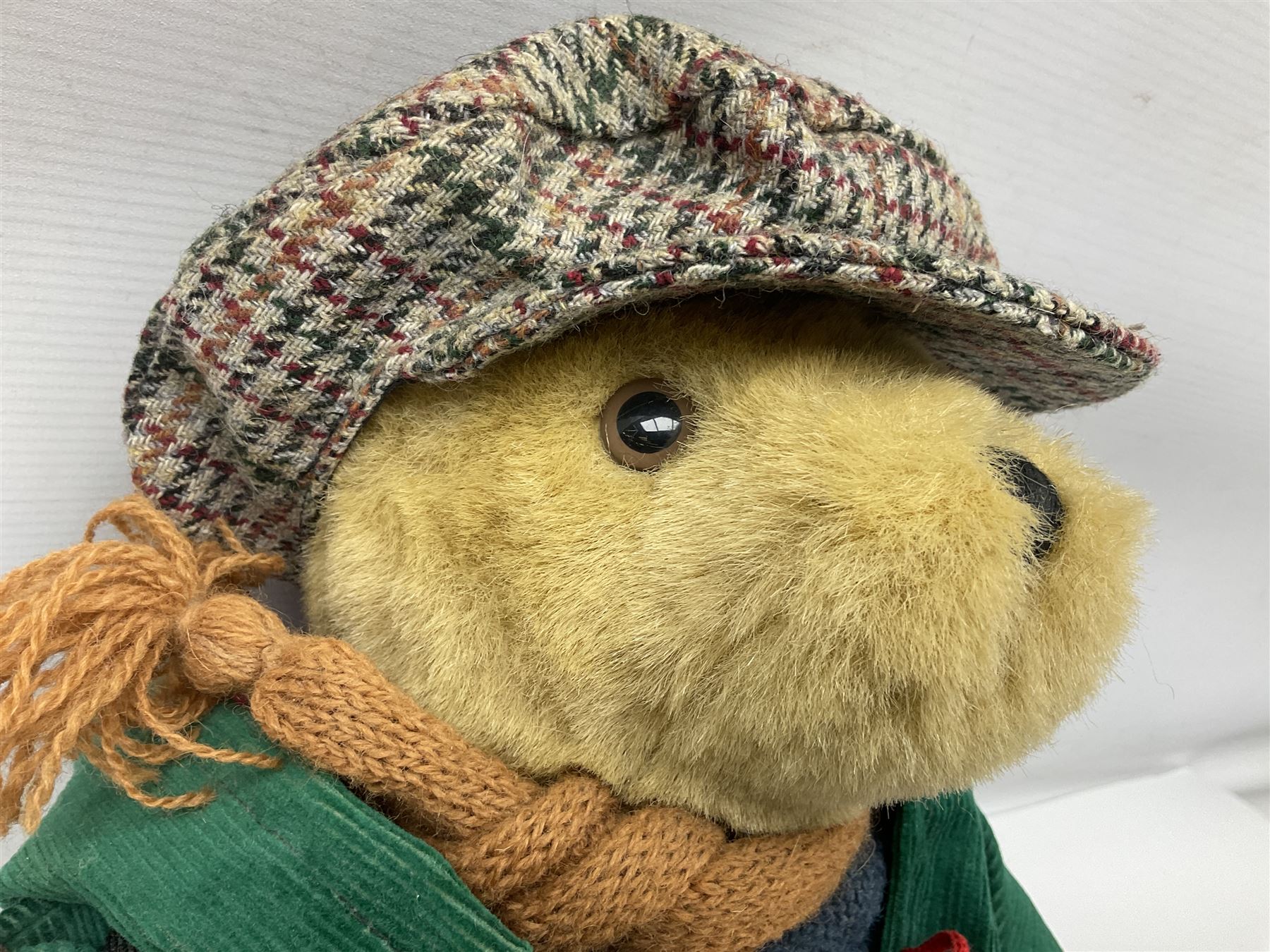 Lakeland Bears teddy bear, titled 'Walkright', dressed as a hiker in green corduroy duffle coat over fair isle jumper, trousers and knit socks, complete with leather clogs with wood soles, walkers thumb stick, knitted scarf, flat cap and rucksack housing original tag and map, H50cm
