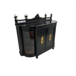 Victorian ebonised credenza side cabinet, raised balustrade back with urn finials and a central carved cartouche, carved and gilded with floral garland decoration, central doors with gilt panels painted with figures sitting over a lake enclosing two shelves, flanked by applied bellflower detail and glazed bow-front side doors, raised on ring turned feet with castors