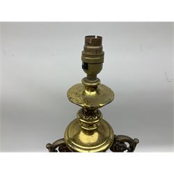 Gilt metal urn shaped lamp on stepped plinth base set with stylised foliate mounts, with fabric shade with tassel detail, without shade H70.5cm