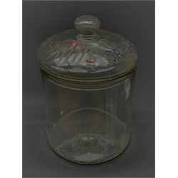 An early 20th century Vintage Smith’s Crisps glass counter top jar, of cylindrical form, the removable domed cover with compressed bun finial inscribed Smith’s Crisps, the body with moulded detail ‘This jar is the property of the Smith’s potato crisps 1929 Ltd’, H25.5cm. 