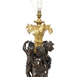 Louis XVI style gilt table lamp, the central column decorated with acanthus leaves, surrounded with three putti with vine leaf crowns, upon a circular base adorned with grape and vines, with shade, H64cm