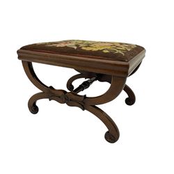 Early Victorian walnut curved x-frame stool, turned stretcher, carved with flower heads, upholstered drop in cushion with needle work cover