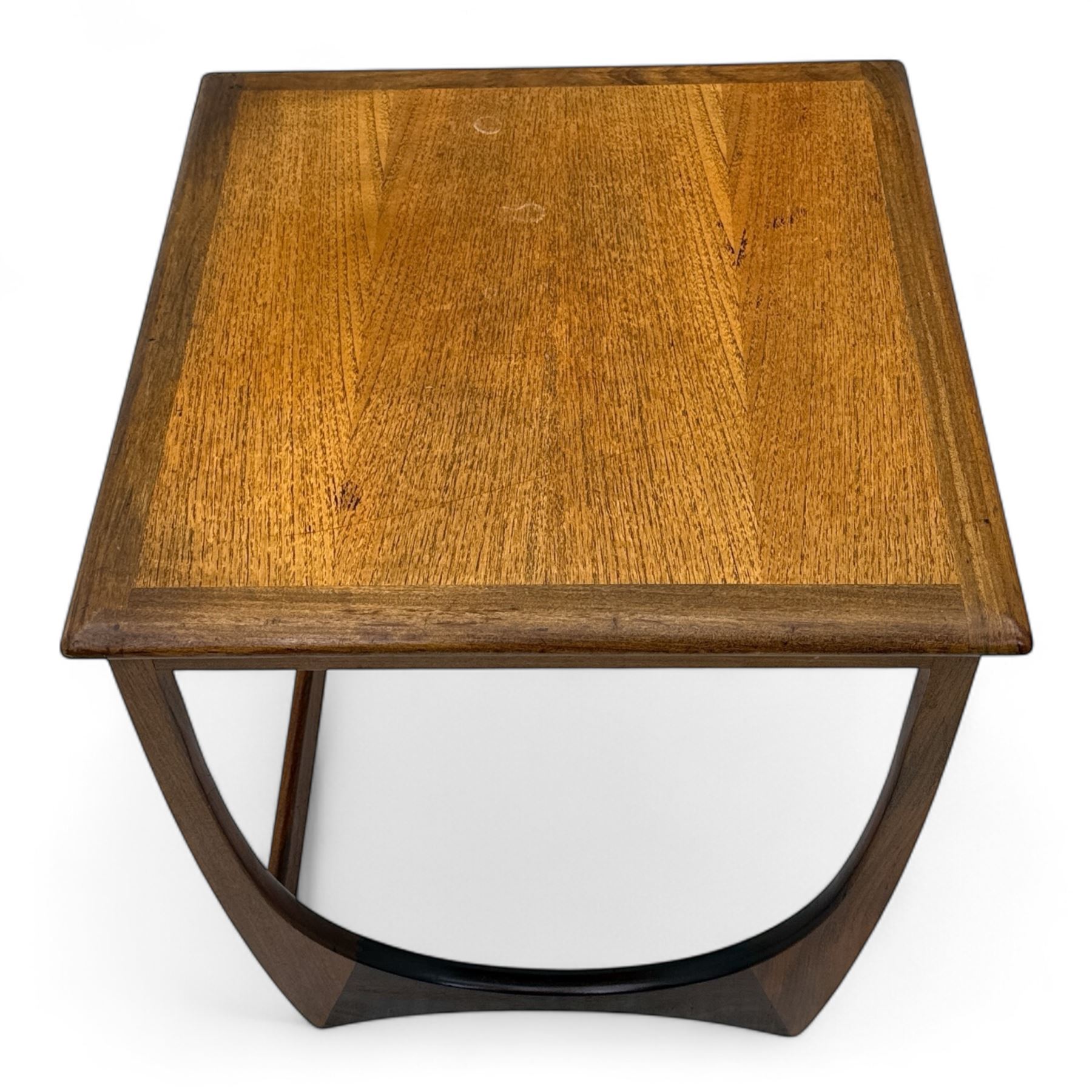 G-Plan - 'Astro' mid-century nest of three teak occasional tables, each with a square top with outer banding, on U-shaped end supports united by a stretcher