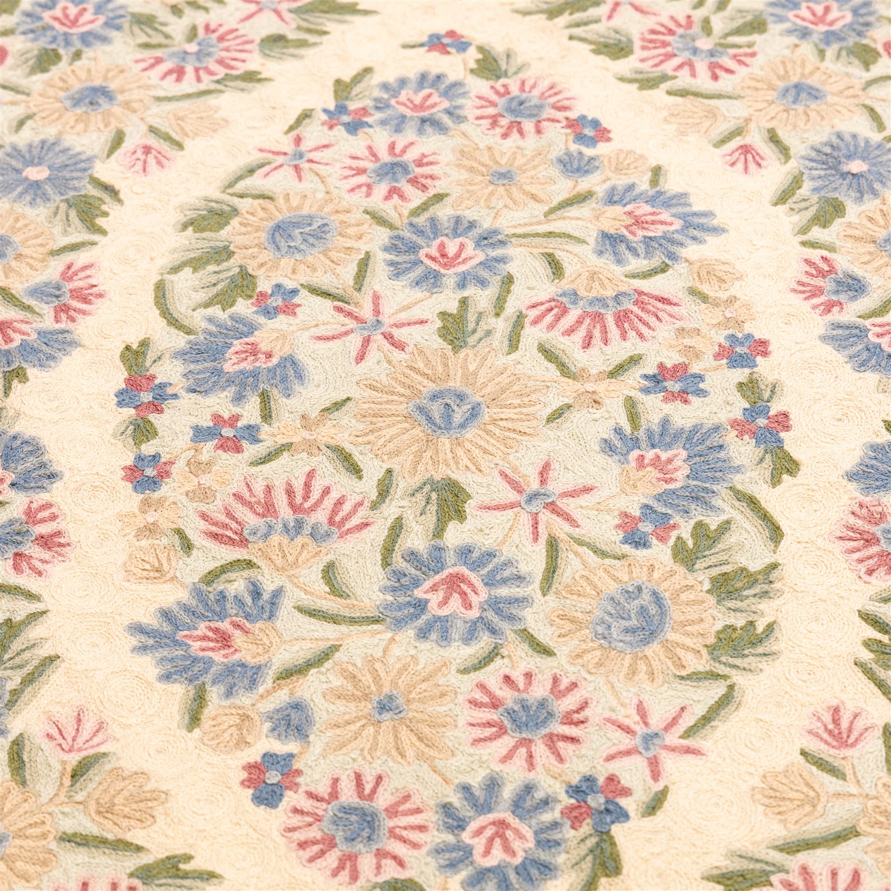 Kashmiri chain stitch crewel embroidered wall hanging, wool on cotton ground, decorated with an all-over lattice of floral medallions and stylized foliage with multiple floral borders