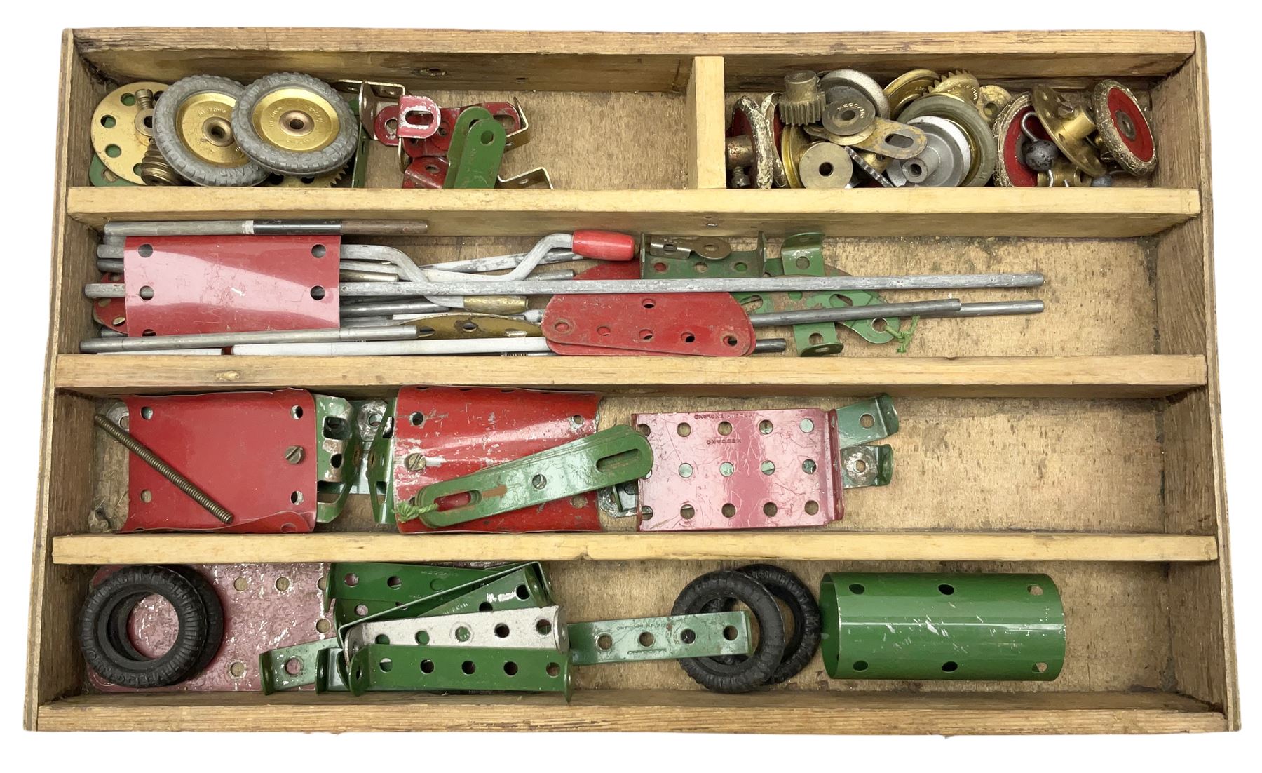 Meccano - wooden box with Set No.5 label to sliding lid, containing two lift-out trays and bottom layer of predominantly red and green sections, wheels, pulleys, rods, tyres etc, carrying handles to either end, L36cm D22.5cm H13.5cm