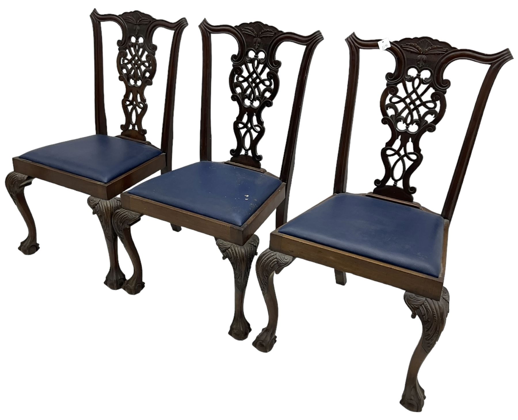 Set of six (5+1) Chippendale design mahogany dining chairs, shaped cresting rail over pierced splat with elaborately carved foliate and scrolling decoration, over drop-in upholstered seats, raised on cabriole supports with scrolled acanthus carved knees and ball and claw carved terminals
