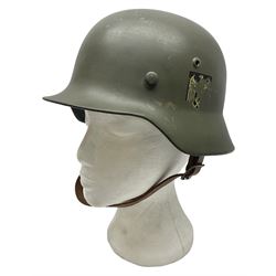 German M35 style steel helmet marked ET60 to the side skirt and 4197 to the back apron, the leather liner with impressed makers mark for 'Schuberth Werke KG Braunschweig 19 60 37' and stamped 53, chin strap and drab green paintwork with traces of two decals