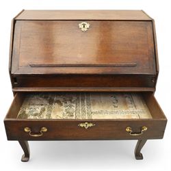 Early 18th century George I oak bureau on original stand, the fall front enclosing an arrangement of correspondence drawers and pigeonholes over central well, fitted with single long drawer below, the shaped apron over cabriole supports with pad feet