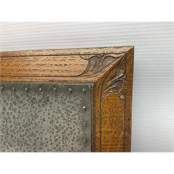 Arts and Crafts oak stand by Arthur Simpson of Kendal, of rectangular form with central hammered pewter panel, surrounded by a border with carved foliate corners, upon two bar supports, bearing label detailed 