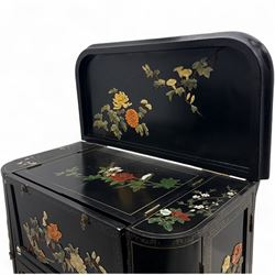 Early 20th century Chinoiserie lacquered cabinet, rounded rectangular top above a fall front enclosing fitted interior with lacquered decoration, over a pair of cupboard doors and flanked by side compartments with tiered bottle shelves, the black lacquer ground decorated throughout with raised and painted floral sprays, on shaped bracket feet