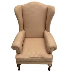 20th century walnut framed wingback armchair, upholstered in pink fabric with squab cushion, raised on cabriole front supports
