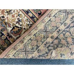 Large Persian design peach ground carpet, the field decorated with floral medallion, multi-band border decorated with repeating flower head pattern