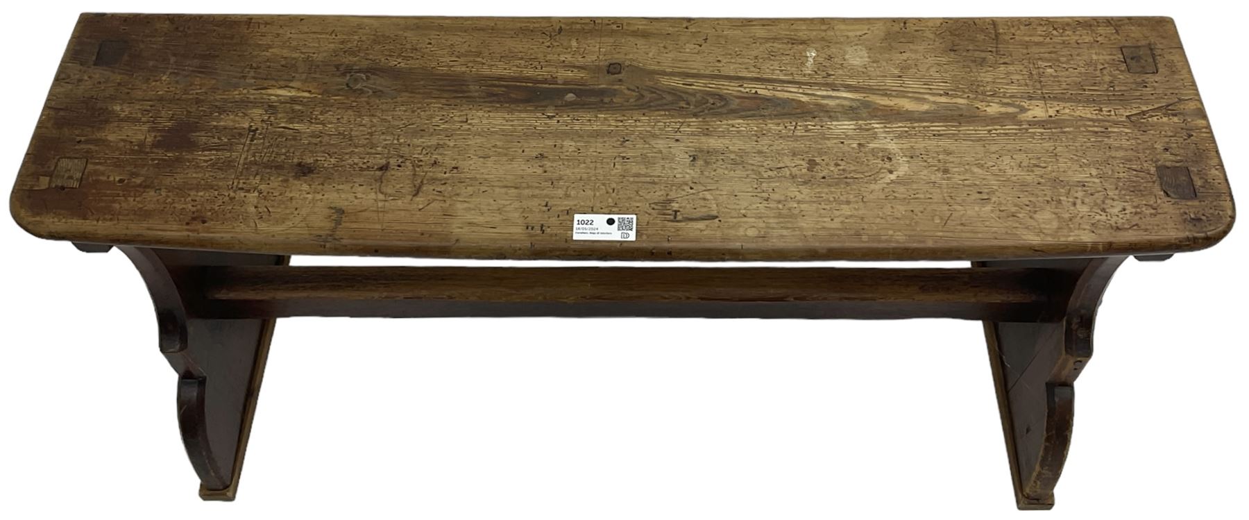 Late Victorian ecclesiastical pitch pine side table, rectangular bow-front top, on shaped end supports pierced with quatrefoils, united by pegged stretcher 