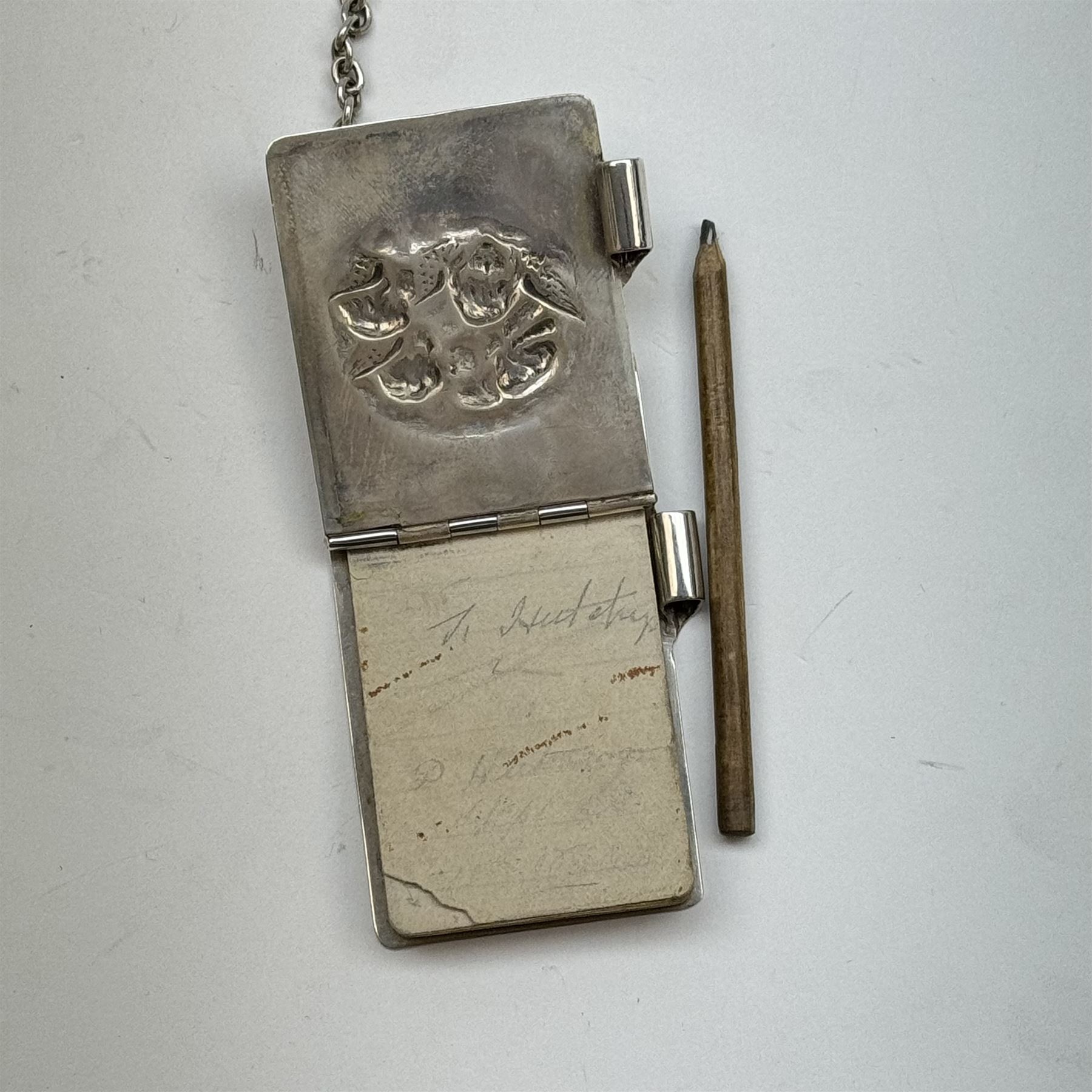 Victorian and later silver chatelaine, the shaped and foliate pierced clasp with embossed oval panel of a courting couple, hallmarked Levi & Salaman, Birmingham 1899, supporting six accessories on five chains: a circular mirror embossed with putti, hallmarked Henry Matthews, Birmingham 1911, pencil holder engraved with foliate scrolls, hallmarked Francis Webb, Birmingham 1914, conical scent bottle decorated with bamboo, (unmarked but testing as silver), aide memoire embossed with putti, hallmarked Samuel M Levi, Birmingham 1911, tape measure of compressed spherical form, hallmarked Henry Matthews, Birmingham 1899, and a purse with embossed putti, hallmarked Birmingham 1909, makers mark worn and indistinct, at longest point L31cm

