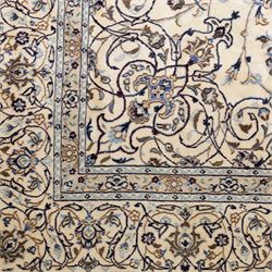 Central Persian Nain hand-knotted carpet, wool with silk highlights, ivory field with central radiating medallion surround by an intricate arrangement of scrolling vines and floral motifs, within conforming spandrels and matching border, cotton fringe ends 