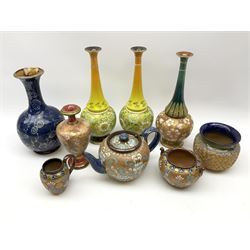 A group of Doulton Lambeth, to include a number of pieces marked Slaters Patent, comprising pair of vases of bottle form with press moulded decoration and yellow ground, H30cm, another vase of similar form, teapot, and open sucrier, and jug with similar decoration, baluster vase with waisted neck, H18cm, and pot with gilt foliate decoration, H10.5cm and a vase of bulbous form with foliate decoration heightened in gilt upon a dark blue ground with various impressed and incised marks and makers monograms. 