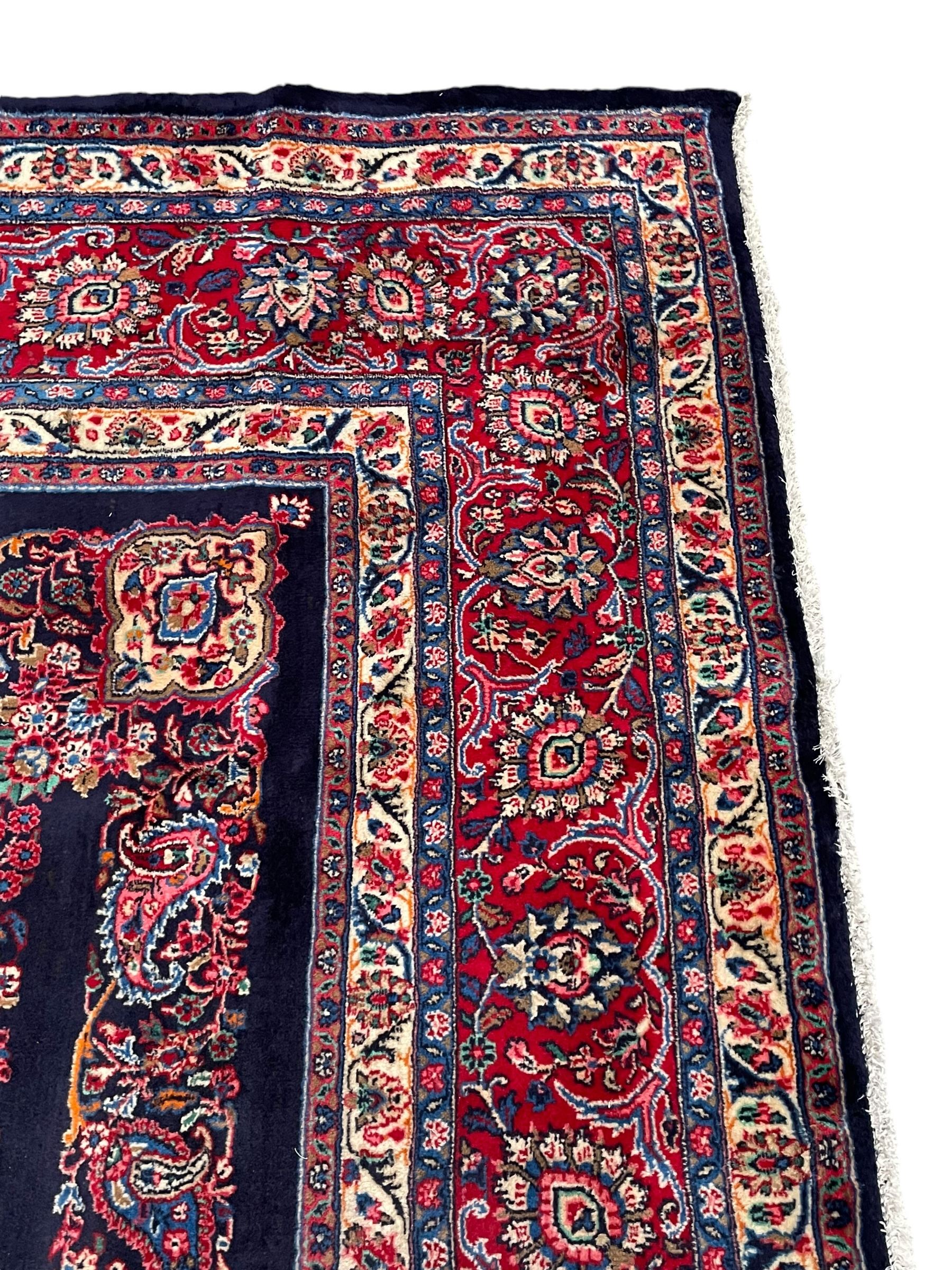 Persian Hamadan indigo ground carpet, the field decorated with central rectangle and outer band, overall floral pattern with cusped central medallion and surrounding leafy branches with palmettes, the border with scrolling branches decorated with further palmettes, within floral pattern guard stripes