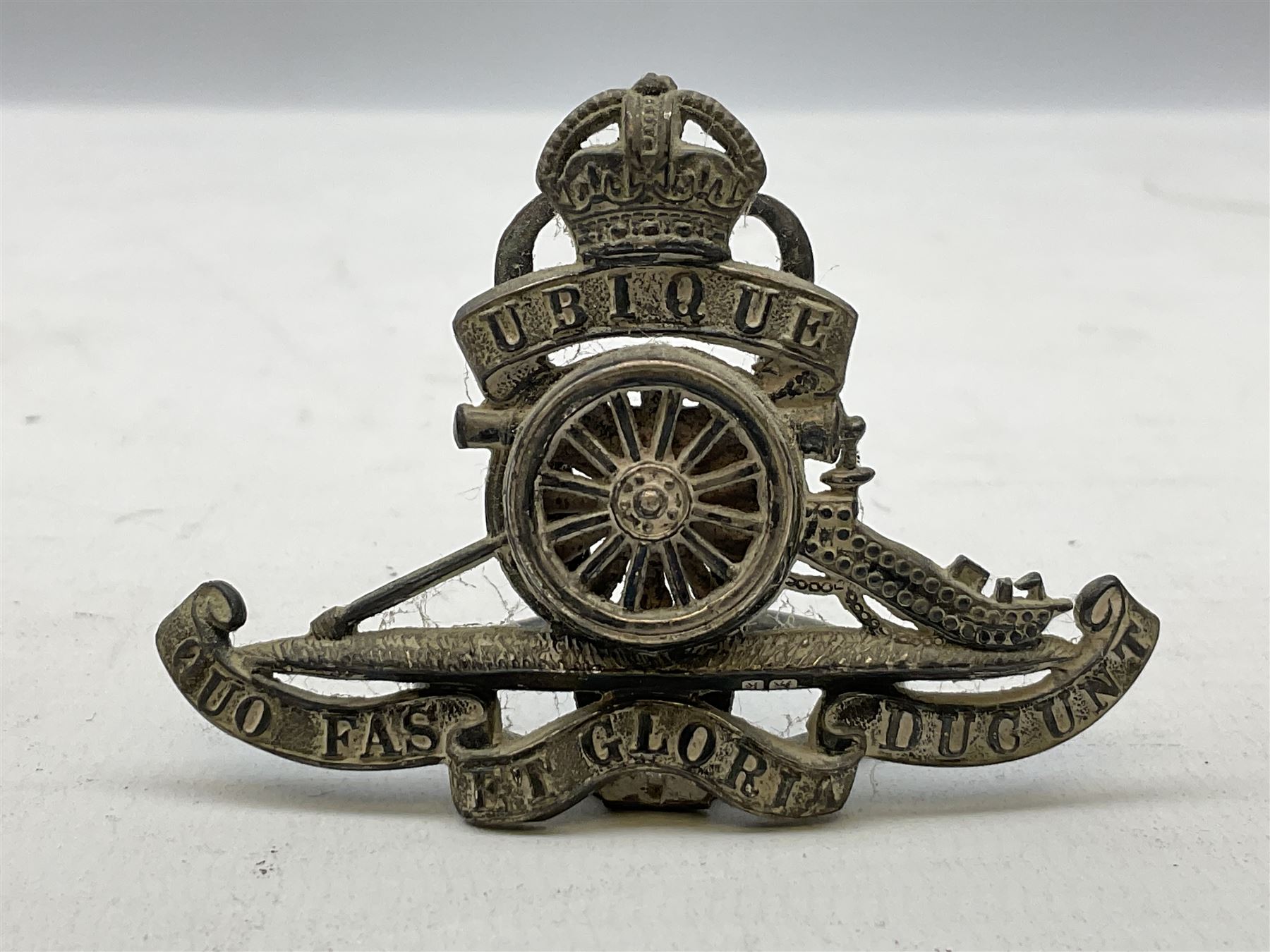 Trench Art - three WW2 brass shell case ashtrays, one mounted with Royal Artillery cap badge and button and one mounted with RA button; together with a pair of place name holders each formed from a Royal Artillery cap badge (5)