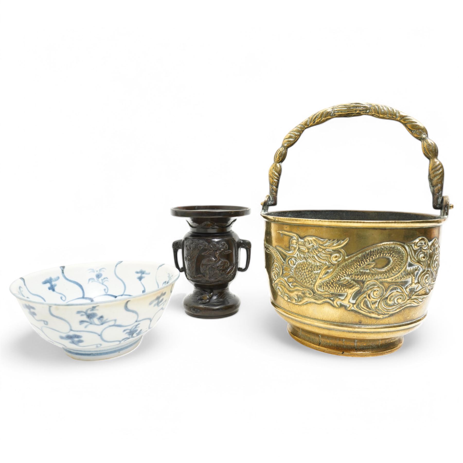 Chinese 20th century polished bronze rice pot with swing handle and raised pattern of dragons D18cm, Meiji period Japanese bronze two handled vase H13cm and a Chinese porcelain bowl from the Tek Sing cargo D15cm (3)