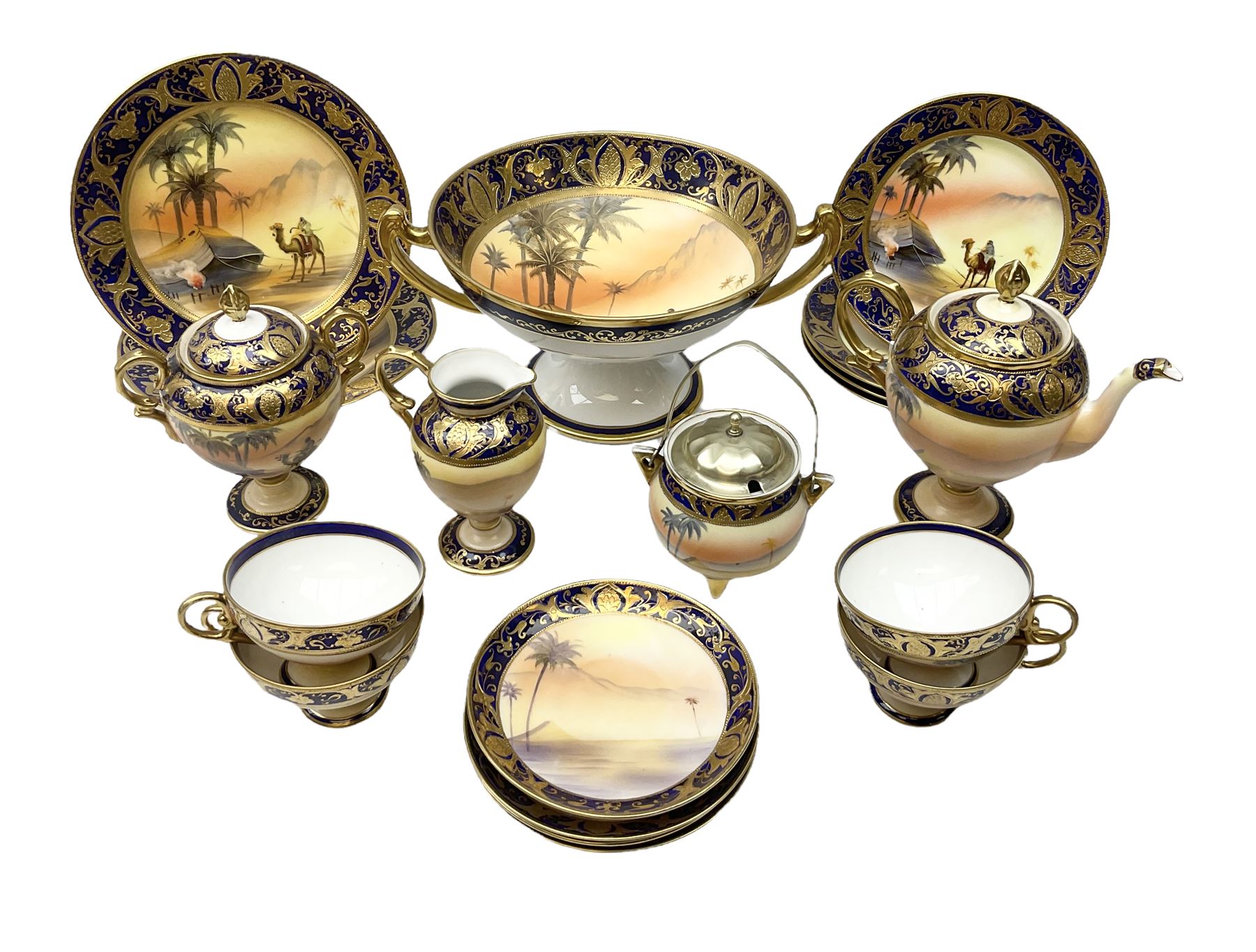 Noritake tea service for four, decorated with desert camel scene with blue border and gilding, comprising four teacups and saucers, four side plates, lidded sucrier, teapot and jug, together with twin handled pedestal bowl etc (19 pcs) 
