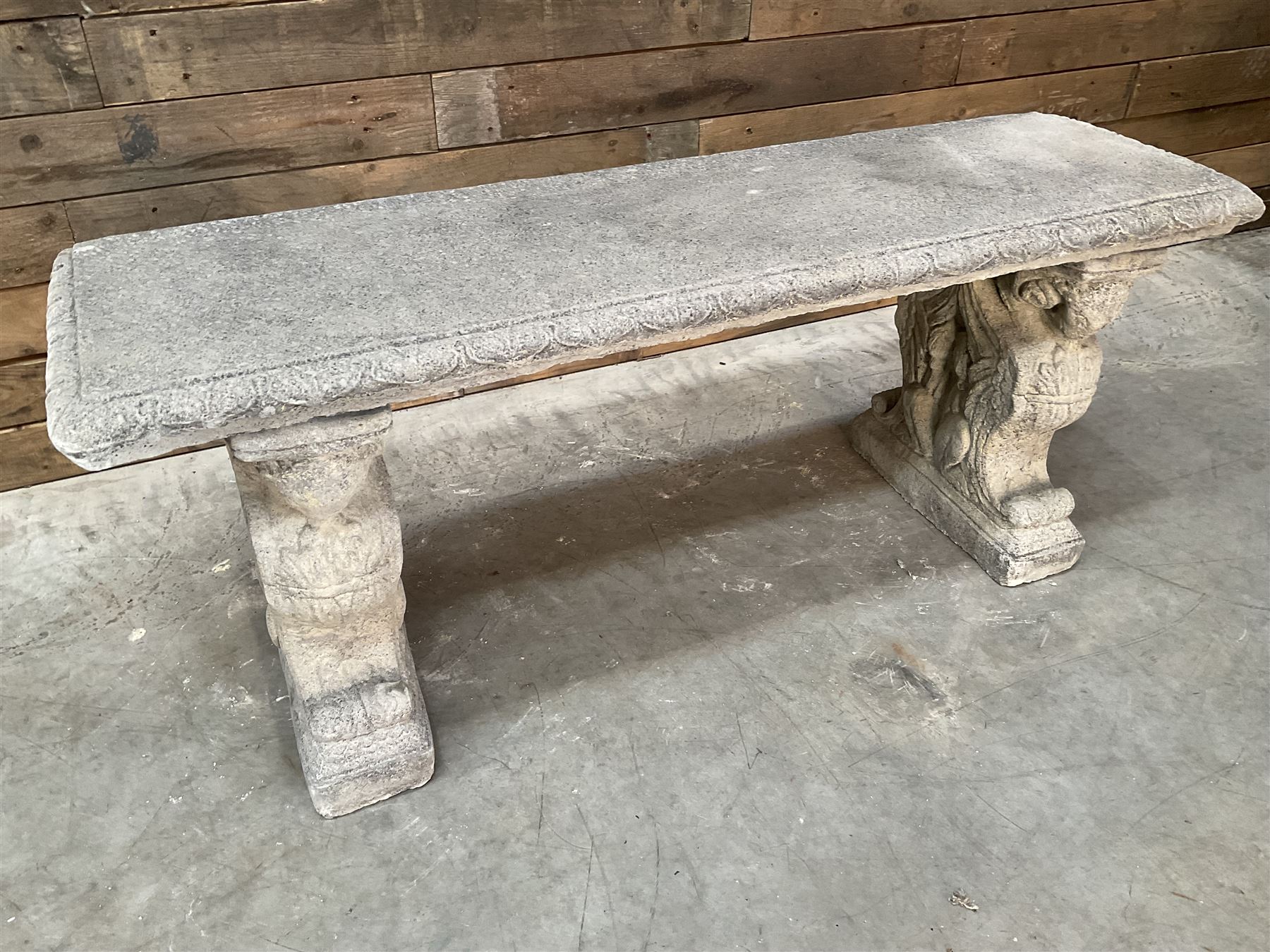 Cast stone garden Rams Head bench, two pillars set with architectural rams heads, rectangular slab seat