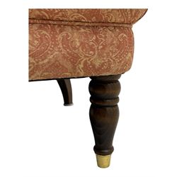 Late Victorian nursing chair, of tub form with deep buttoned backrest, upholstered in pink damask fabric with foliate motifs, raised on turned mahogany legs with brass caps