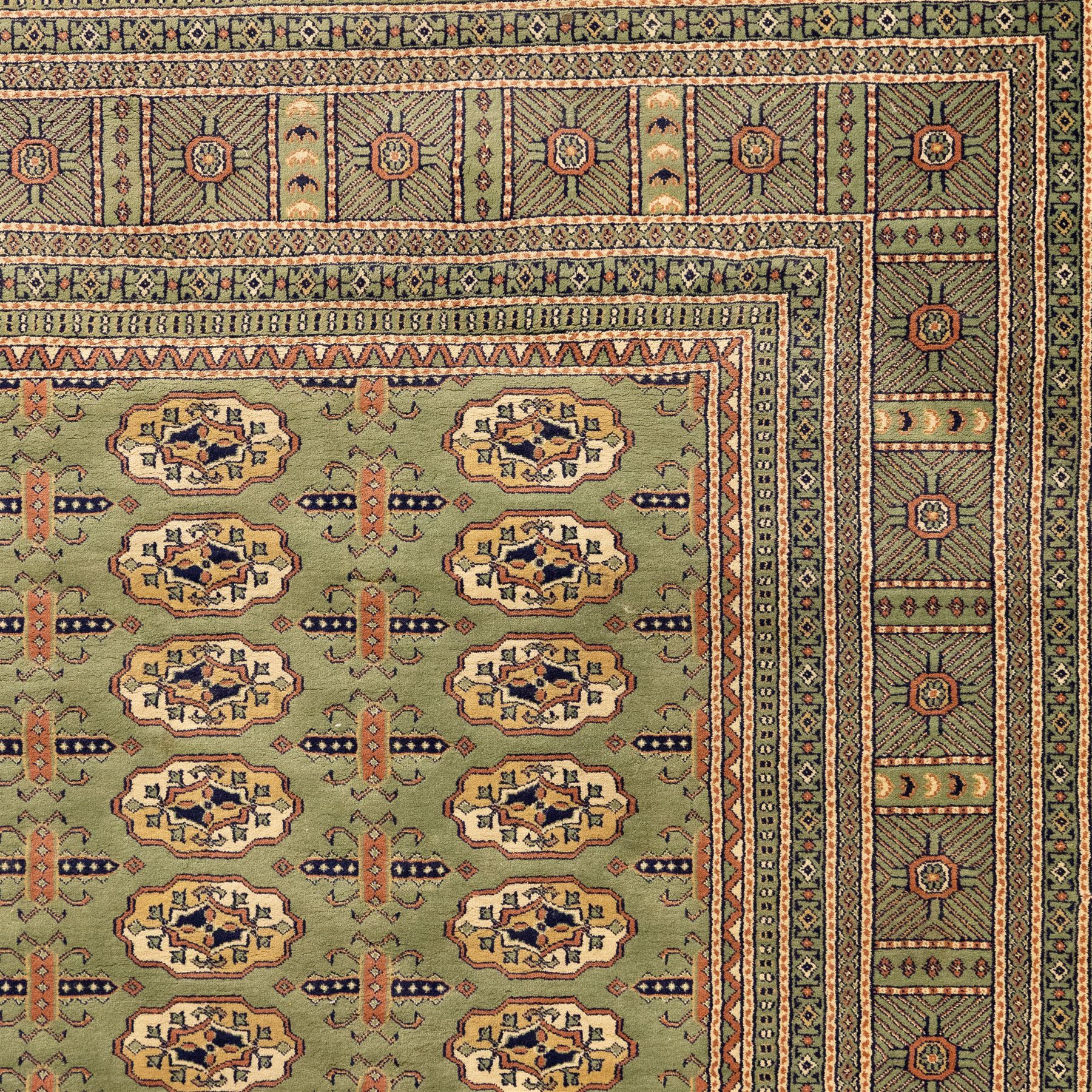 Turkish Bokhara design rug, olive green field decorated with an all-over design of repeating gul motifs arranged in rows, enclosed by a series of narrow and wide geometric borders with diamond and star devices 