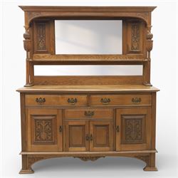Arts and Crafts oak mirror back sideboard, the bevelled rectangular mirror set within a back with foliate carved panels, with turned baluster and knopped supports, upon a base with moulded top above three drawers  and three cupboard doors, two with carved foliate detail, upon four shaped bracket feet