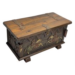 Mid-20th century carved hardwood chest, the rectangular hinged top with decorative strap hinges, the front and sides deeply carved with medieval-style jousting knights, heraldic shields, and architectural elements, raised on shaped block feet