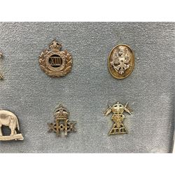 Twenty-eight cap badges for Hussars, Lancers, Dragoon Guards etc including 5th, 9th, 12th, 16th, 17th and 21st Lancers, Kings Own Hussars, 19th P.W.O. Hussars, 8th Kings Royal Irish Hussars, 4th Queens Own Hussars, Kings Dragoon Guards, 4th Royal Irish Dragoon Guards etc; mounted for display in a metal frame 41.5 x 62cm