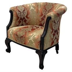 Early 20th century mahogany framed upholstered tub armchair, scrolled arms, upholstered in a damask-style fabric with foliate pattern, raised on cabriole front legs upon brass castors