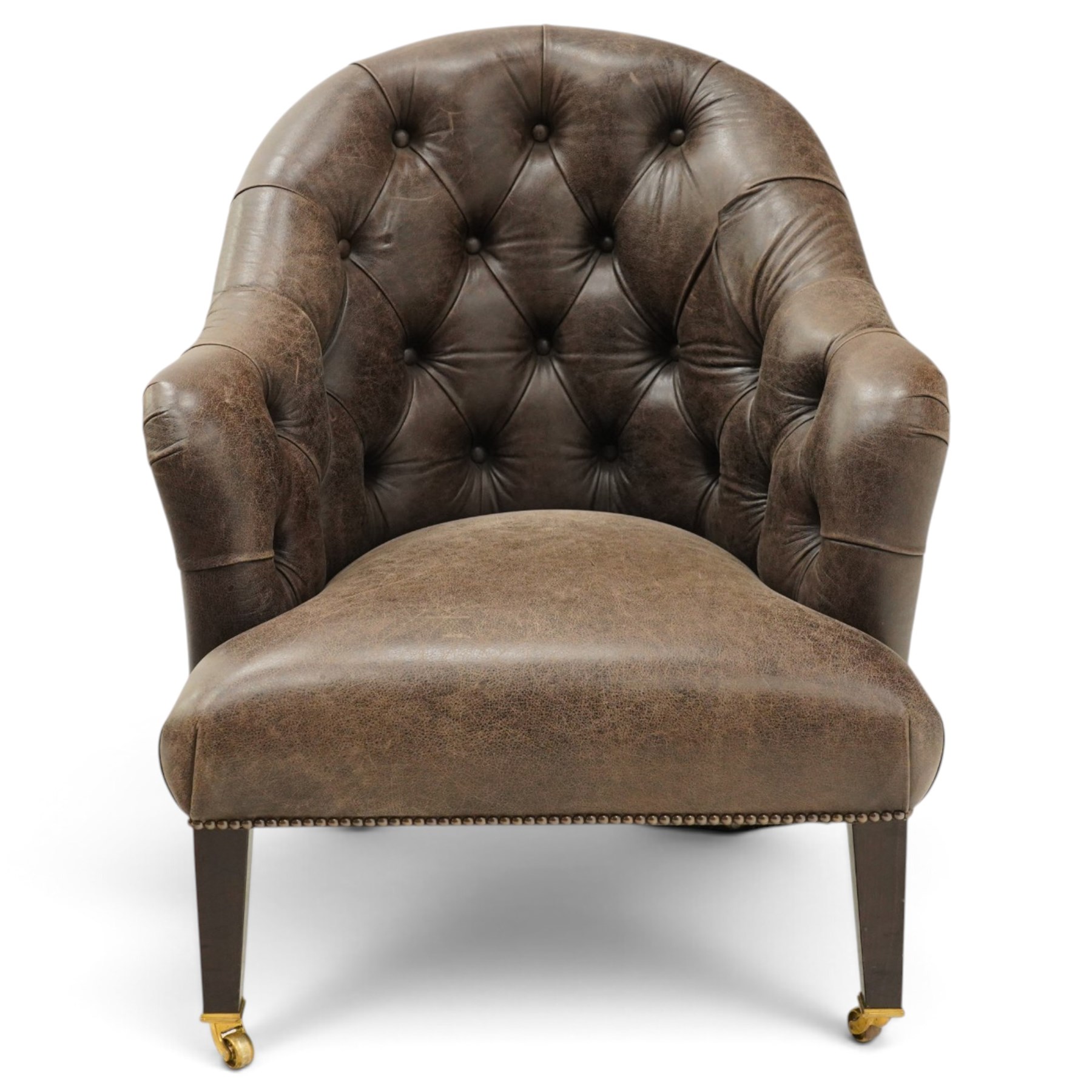 Georgian design tub-shaped club armchair, upholstered in back-buttoned dark tan leather with sprung seat, raised on square tapering supports with brass cups and castors