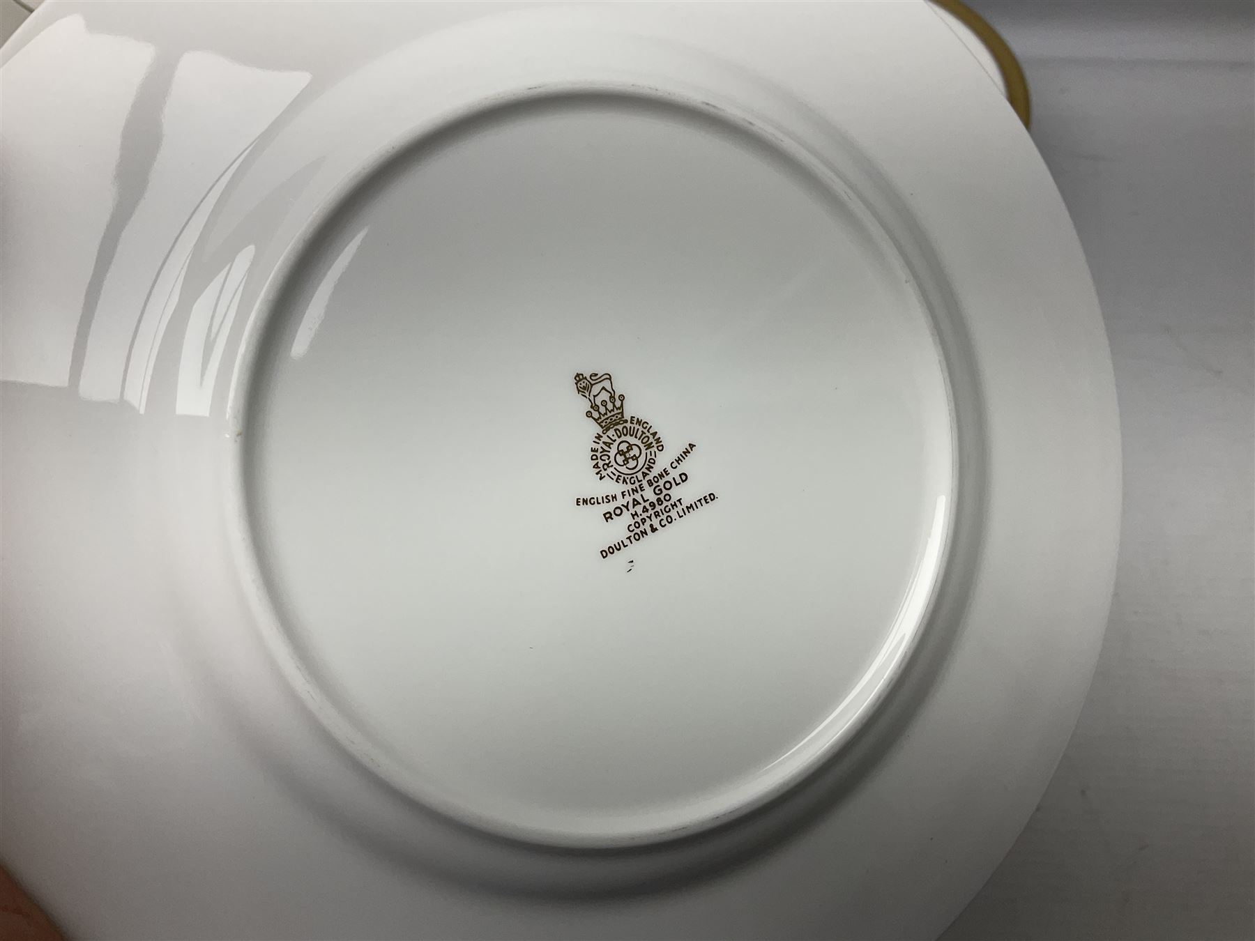 Royal Doulton Royal Gold pattern tea and dinner service for eight, comprising dinner plates, side plates, tea plates, soup bowls, sauce boat and saucer, dessert bowls, coffee cans and saucers, teacups and saucers and two lidded tureens