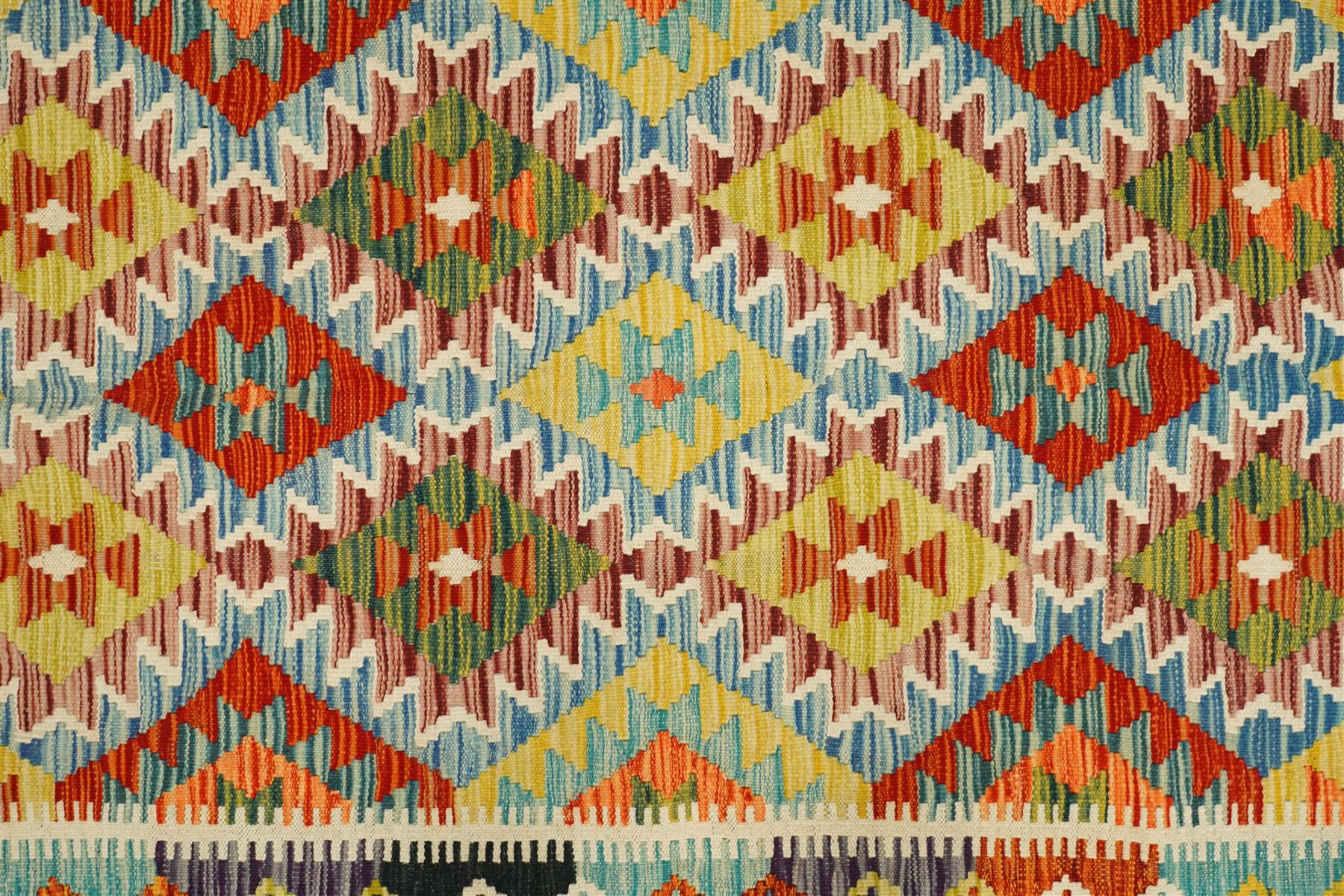 Chobi kilim with staggered diamond and stepped lozenge motifs in a palette of mustard, rust, teal, lilac and cream, the design enclosed by patterned guard stripes