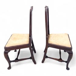 Pair of early 18th century walnut side chairs, vase-shaped splats beneath shaped top rails, drop-in seats upholstered in floral damask, on cabriole front legs terminating in pad feet, united by turned stretchers