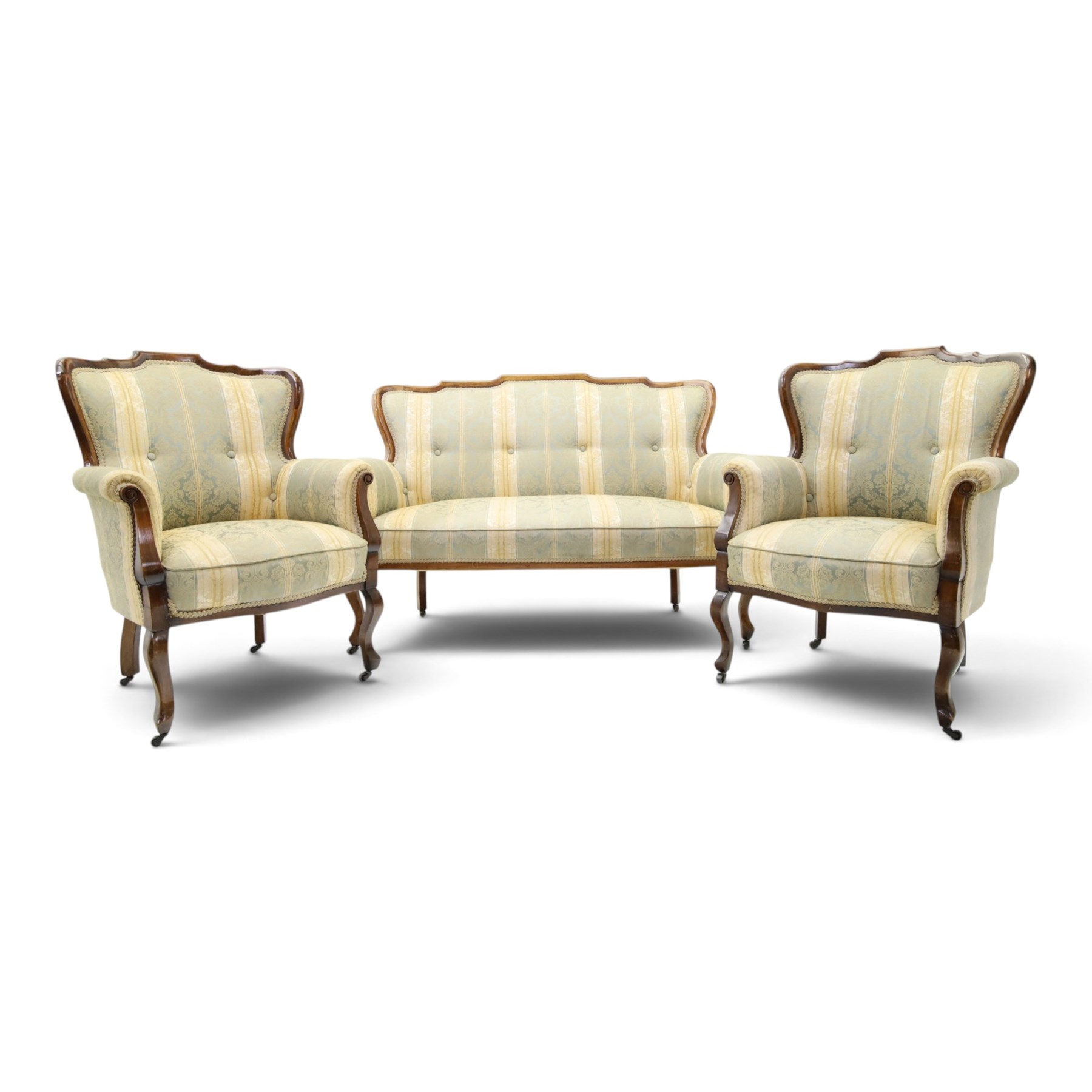 Edwardian mahogany three-piece salon suite, comprising settee and two armchairs, shaped frames with upholstered backs, scrolled arm supports and serpentine seat rails, upholstered in striped floral damask fabric, on cabriole supports with castors (Armchairs: H 96cm, W 70cm, D 68cm)