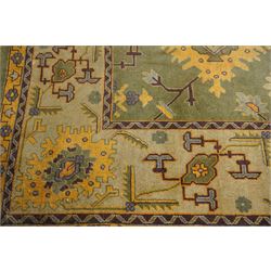 Lage Turkish Oushak green ground carpet, the field decorated with large stylised plant motifs and geometric design, the sage green guard band with further repeating foliate motifs