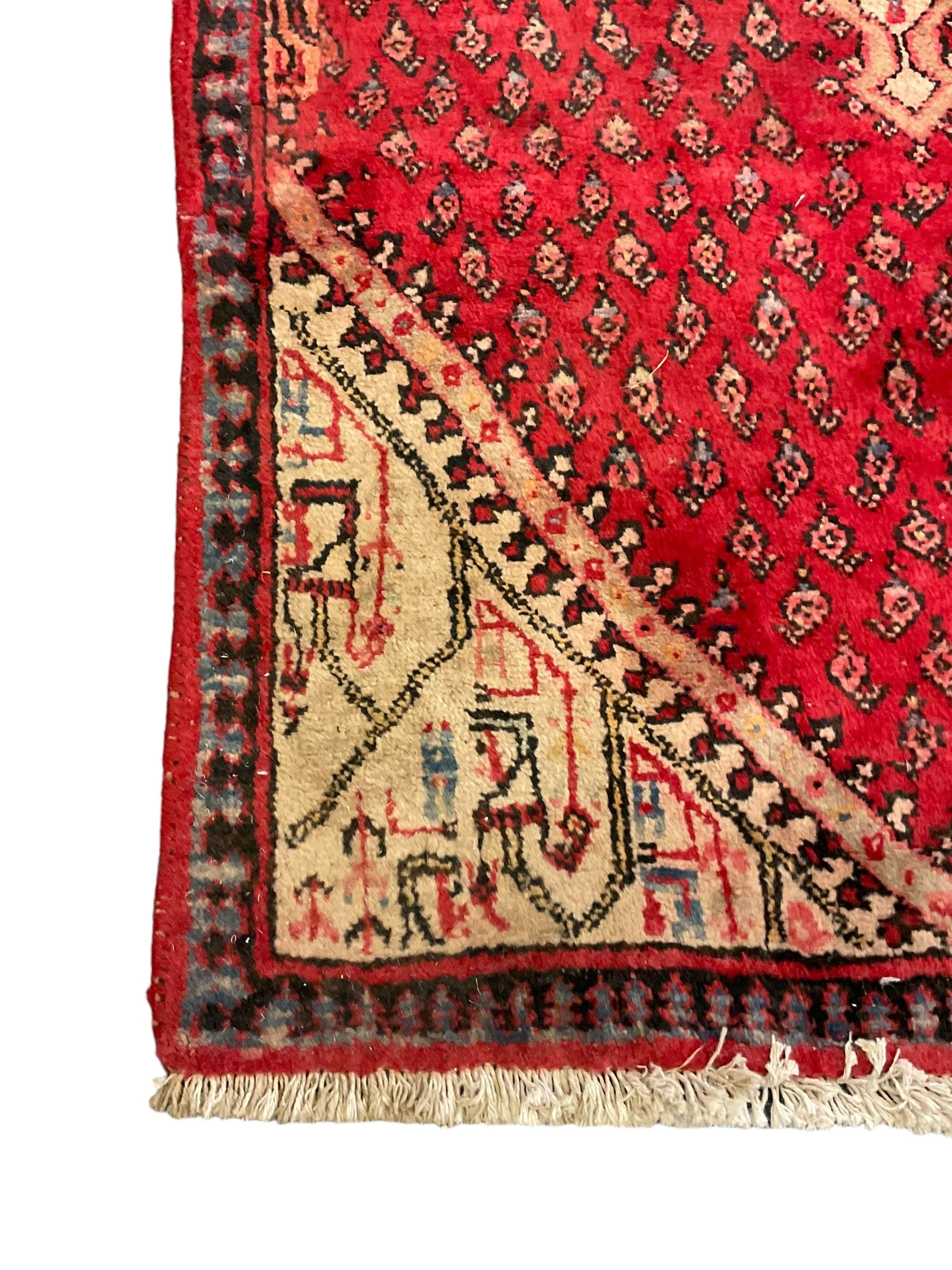 Small Persian red ground rug, lozenge medallion surrounded by small Boteh motifs